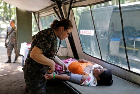 A doctor gives a woman a health check up during a temporary state of siege, approved by the Guatemalan Congress following the death of several soldiers last week, in the community of Semuy II, Izabal province