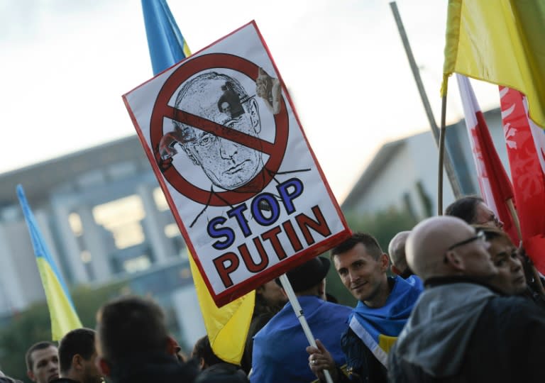 Protester demonstrate outsiude the chancellery in Berlin ahead of a meeting of leaders of Russia, Ukraine, France and Germany