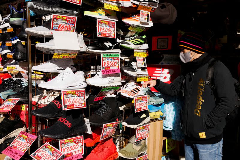 FILE PHOTO: Man looks at sport shoes at a market in Tokyo