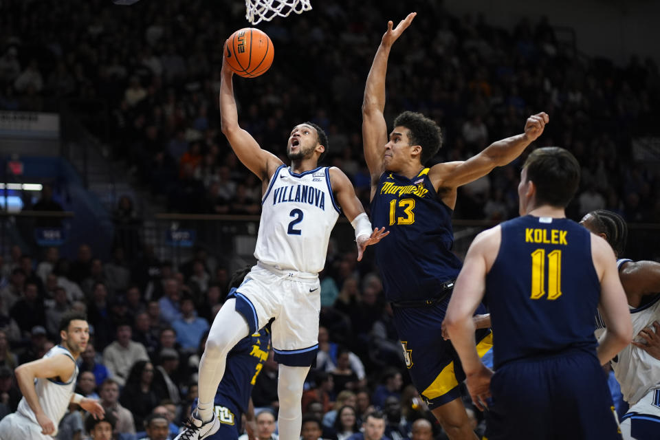 Villanova's Mark Armstrong (2) goes up for a shot against Marquette's Oso Ighodaro (13) during the second half of an NCAA college basketball game, Tuesday, Jan. 30, 2024, in Villanova, Pa. (AP Photo/Matt Slocum)