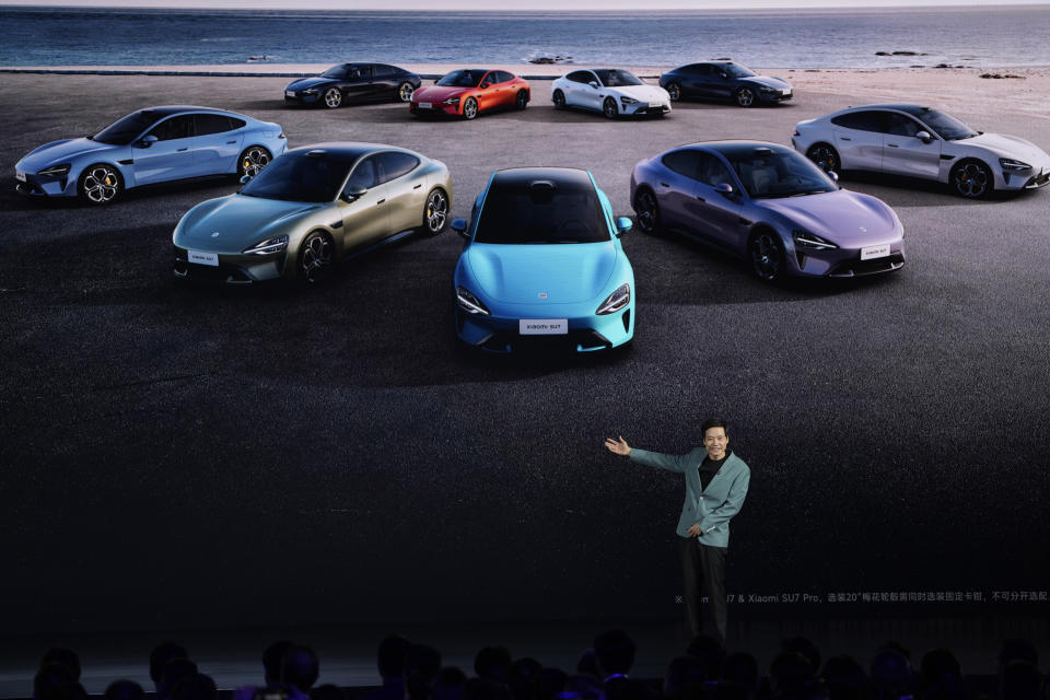 Xiaomi founder Lei Jun shows off the multiple colours of the SU7, a sporty four-door sedan, during a launch event in Beijing, Thursday, March 28, 2024. Xiaomi, a well-known maker of smart consumer electronics in China, is joining the country's booming but crowded market for electric cars. (AP Photo/Ng Han Guan)