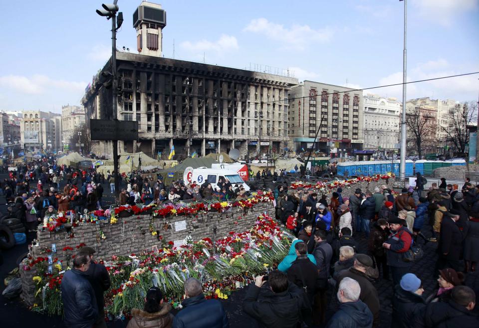 People lay flowers at the barricades in memory of the victims of the recent clashes in central Kiev