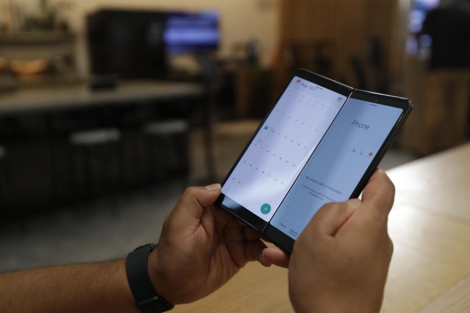 A person demonstrates the ability of the Samsung Galaxy Fold 3 to display two apps at once, on Monday, Aug. 9, 2021 at Samsung KX in London. Samsung is hoping cheaper but more durable versions of its foldable phones will broaden the appeal of a high-concept design that’s so far fizzled with consumers. (AP Photo/Tristan Werkmeister)