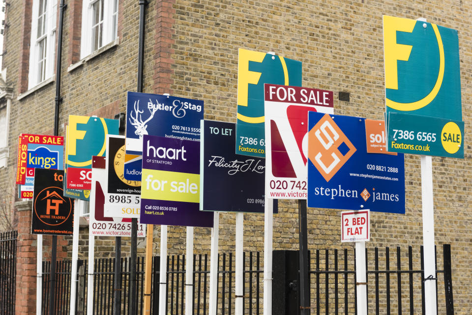 house prices London, England, United Kingdom - February 11, 2015: FOR SALE and TO LET real estate agent signs outside residential housing development in Hackney. Many house rental and sales agency signs in a row. Multiple sign boards.