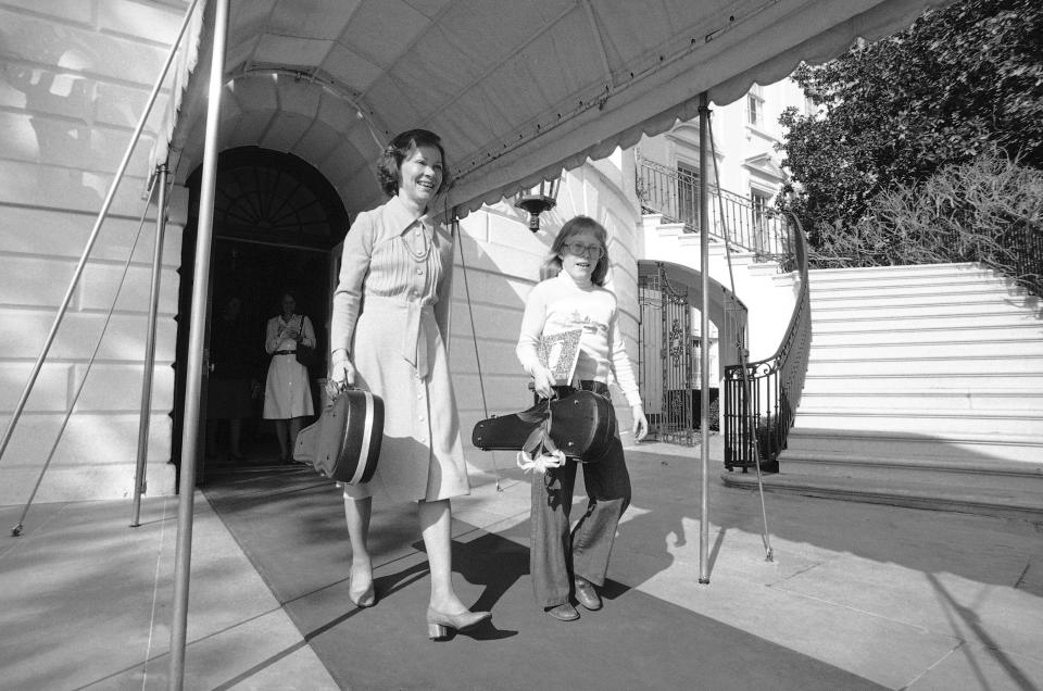 FILE - First lady Rosalynn Carter, left, and daughter Amy leave the White House in Washington, March 26, 1978, for a violin suburban Virginia. Carter, the closest adviser to Jimmy Carter during his one term as U.S. president and their four decades thereafter as global humanitarians, has died at the age of 96. (AP Photo, File)