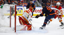 Calgary Flames goalie Jacob Markstrom, left, lets in a goal from Edmonton Oilers winger Evander Kane during the second period of an NHL hockey Stanley Cup second-round playoff series game in Edmonton, Alberta, Sunday, May 22, 2022. (Jeff McIntosh/The Canadian Press via AP)