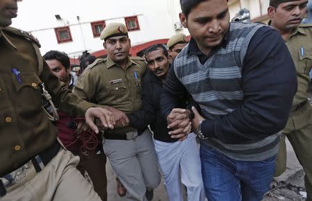 Policemen escort driver Shiv Kumar Yadav (3rd R in black jacket) who is accused of a rape outside a court in New Delhi December 8, 2014. REUTERS/Adnan Abidi