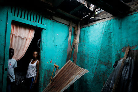 Fara Pierrelouis (R), 32, and Fresno Thelisma, 16, pose for a photograph in their destroyed house after Hurricane Matthew hit Jeremie, Haiti, October 16, 2016. REUTERS/Carlos Garcia Rawlins