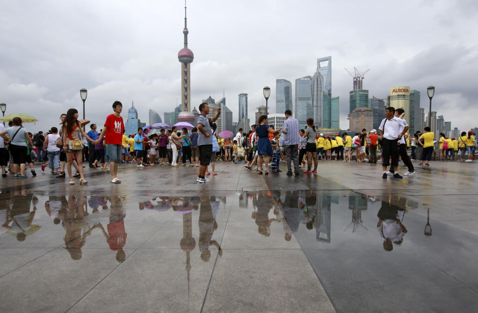 Visitors watch the scenery from the Bund, one of the most popular tourist destination in town, following a brief downpour as Typhoon Saola approaches Thursday Aug. 2, 2012 in Shanghai, China. (AP Photo/Eugene Hoshiko)