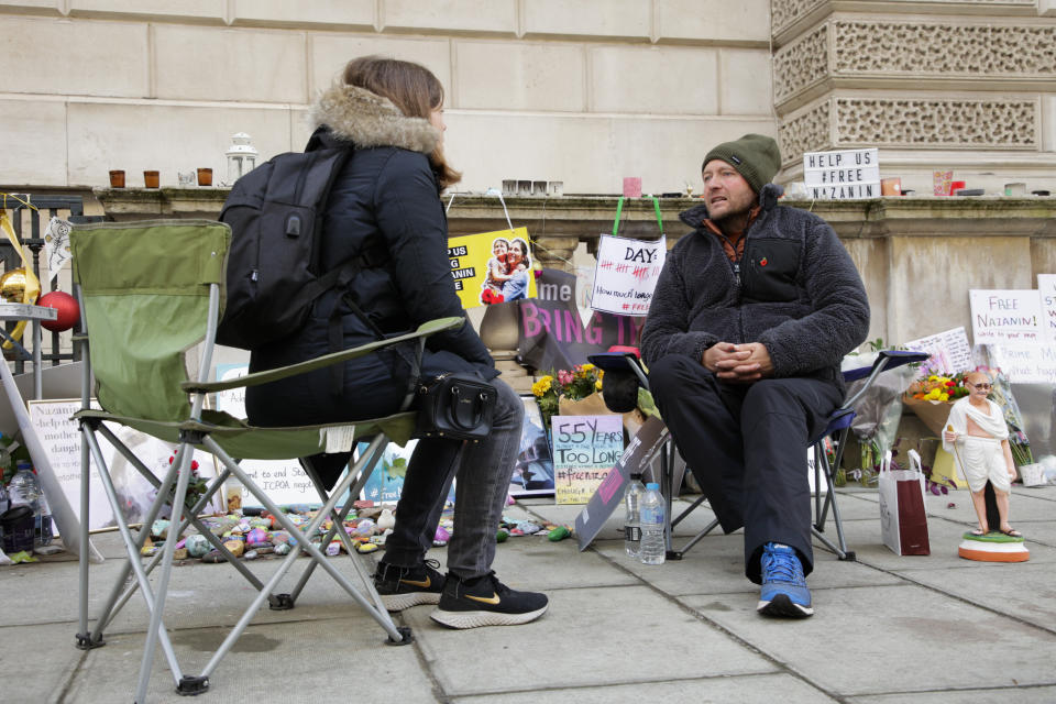 Richard Ratcliffe, husband of detained charity worker Nazanin Zaghari-Ratcliffe, speaks with a journalist as he continues his hunger strike outside the Foreign, Commonwealth and Development Office in London, Thursday, Nov. 11, 2021. Ratcliffe began his hunger strike 19 days ago after a court decided his wife has to spend another year in an Iranian prison, where she has been detained since 2016. (AP Photo/David Cliff)