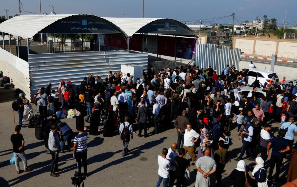 Palestinians with dual citizenship gather at the Rafah border crossing with Egypt (Ibraheem Abu Mustafa/Reuters)