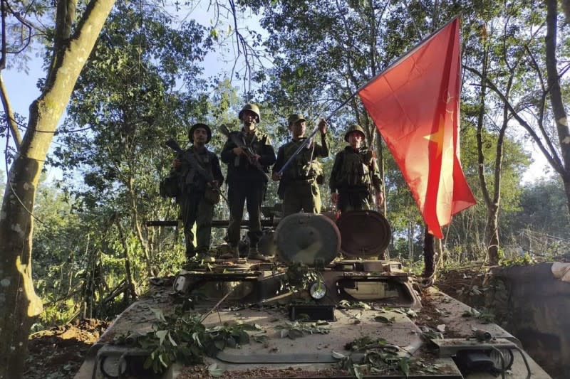 <cite>2023年10月28日，緬甸民族民主同盟軍戰士在一輛被擄獲的緬甸陸軍裝甲車上舉旗合影。（美聯社）</cite>