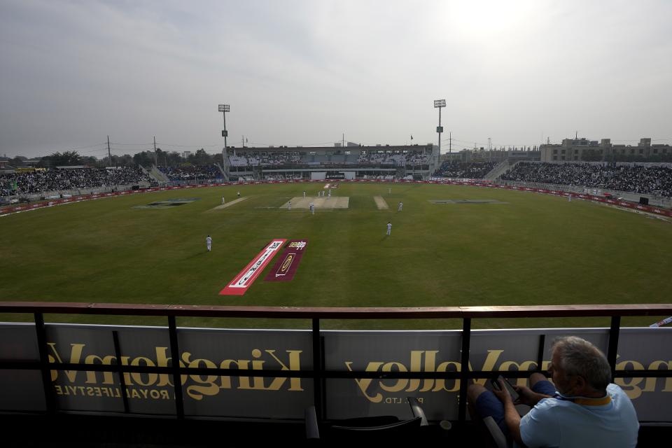 A journalist watches the second day game of the first test cricket match between Pakistan and England, in Rawalpindi, Pakistan, Friday, Dec. 2, 2022. (AP Photo/Anjum Naveed)