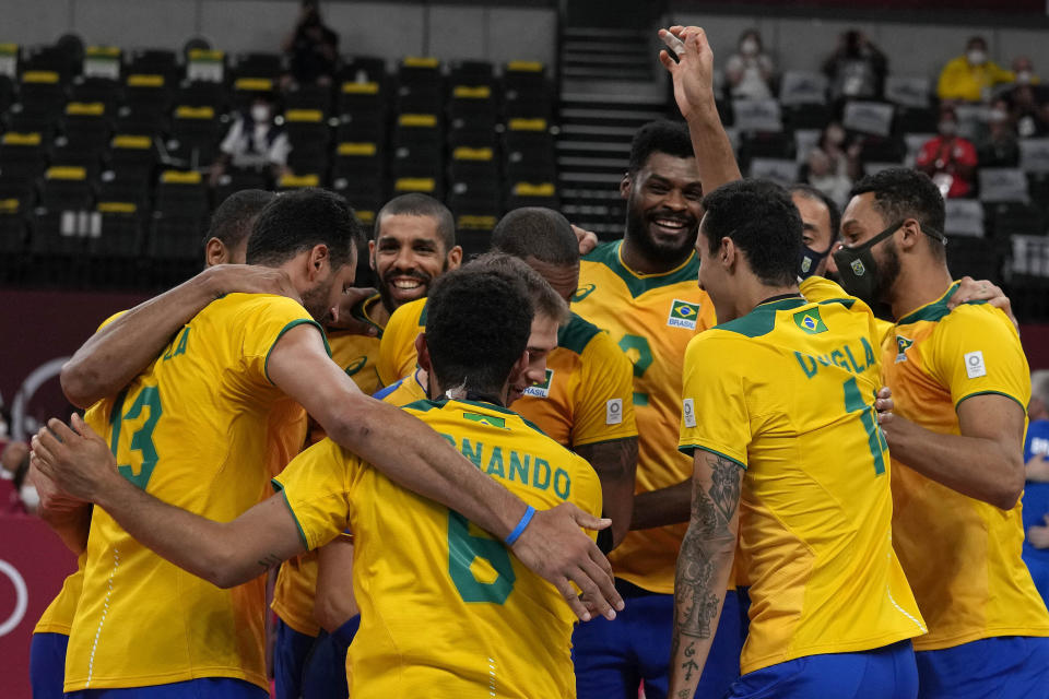 Brazil players celebrate after winning the men's volleyball quarterfinal match between Japan and Brazil at the 2020 Summer Olympics, Tuesday, Aug. 3, 2021, in Tokyo, Japan. (AP Photo/Frank Augstein)