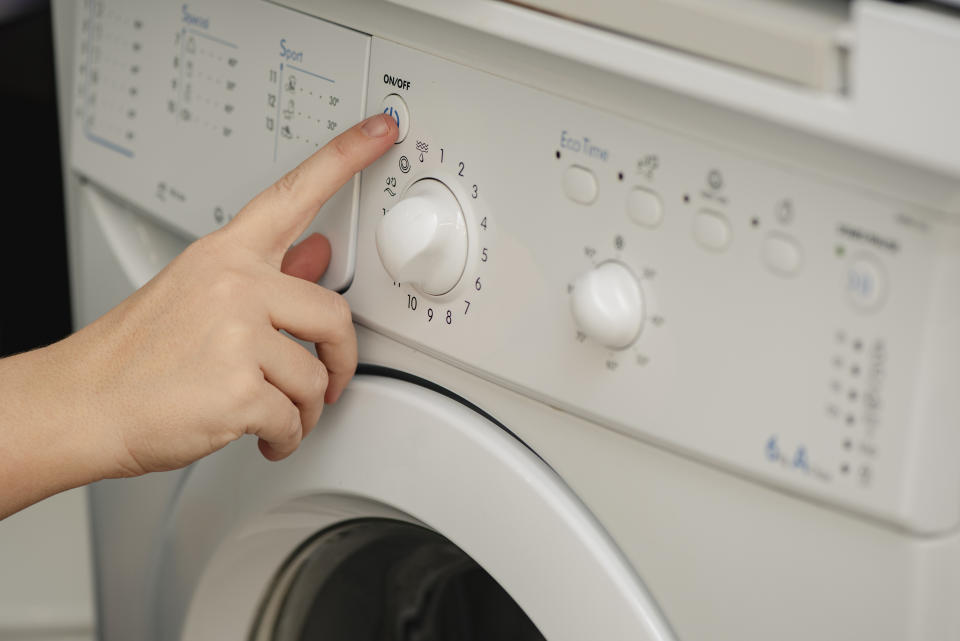 a finger turning on a washing machine