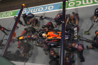 Crew work on the car of Red Bull driver Max Verstappen of the Netherlands during the qualifying session at the Singapore Formula One Grand Prix, at the Marina Bay City Circuit in Singapore, Saturday, Oct. 1, 2022. (AP Photo/Vincent Thian)