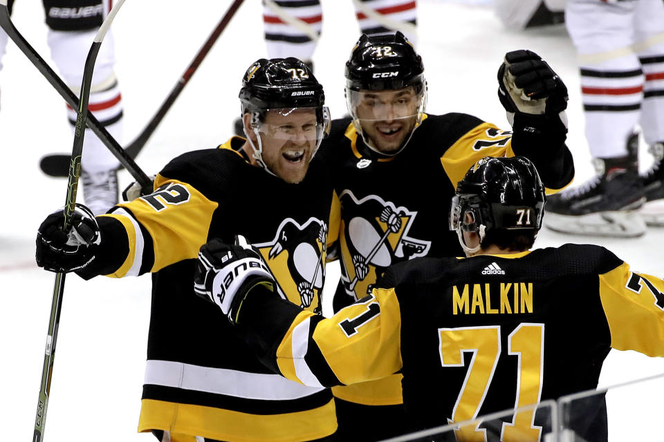 Pittsburgh Penguins' Patric Hornqvist (72) celebrates his goal with Dominik Simon (12) and Evgeni Malkin (71) during the first period of an NHL hockey game against the Chicago Blackhawks in Pittsburgh, Sunday, Jan. 6, 2019. (AP Photo/Gene J. Puskar)