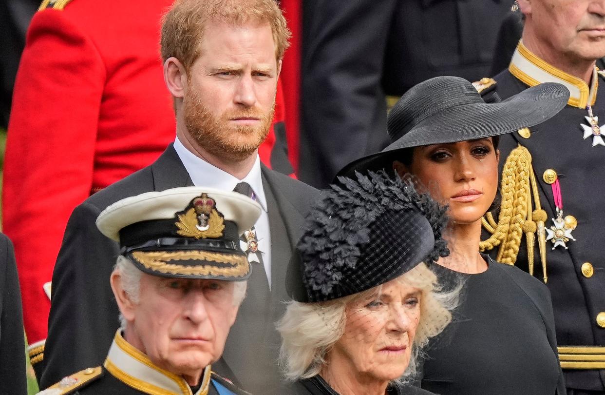 Britain's King Charles III, from bottom left, Camilla, the Queen Consort, Prince Harry and Meghan, Duchess of Sussex watch as the coffin of Queen Elizabeth II is placed into the hearse following the state funeral service in Westminster Abbey on Sept. 19, 2022.