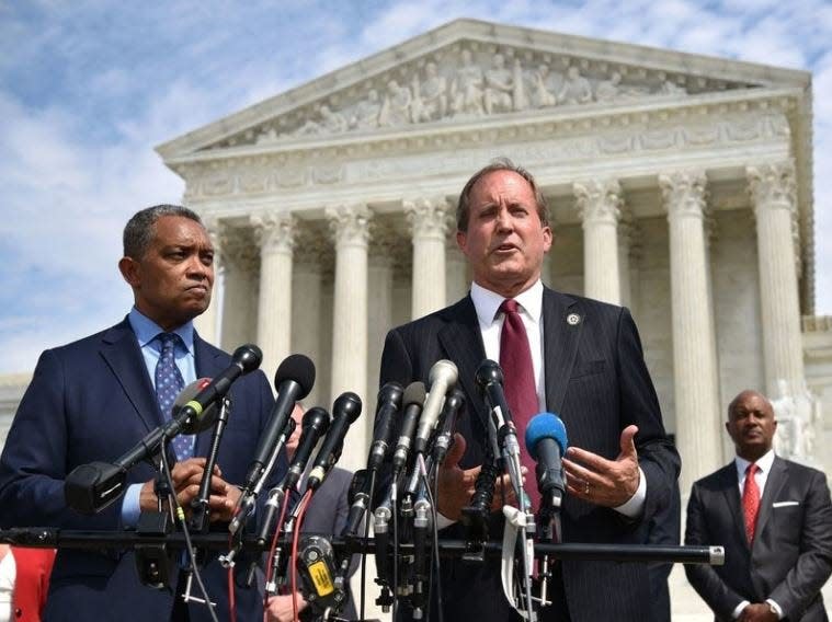 Texas Attorney General Ken Paxton -- flanked by District of Columbia Attorney General Karl Racine -- leads a news conference outside the Supreme Court building in Washington, D.C., last month announcing an antitrust investigation into Google.  [The New York Times]