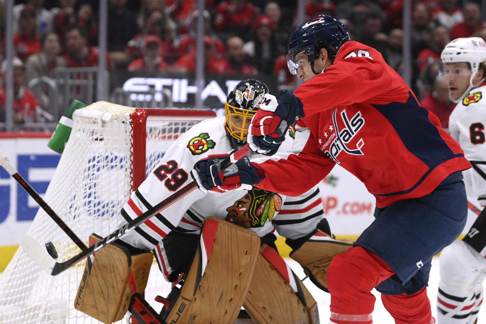 Washington Capitals center Nic Dowd (26) reaches for the puck in front of Chicago Blackhawks goaltender Marc-Andre Fleury (29) during the first period of an NHL hockey game Thursday, Dec. 2, 2021, in Washington. (AP Photo/Nick Wass)