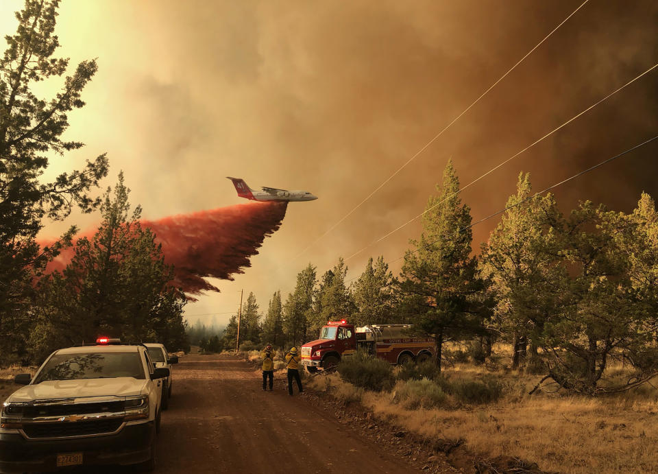 This photo provided by the Oregon Department of Forestry shows a firefighting tanker making a retardant drop over the Grandview Fire near Sisters, Ore., Sunday, July 11, 2021. The wildfire doubled in size to 6.2 square miles (16 square kilometers) Monday, forcing evacuations in the area, while the state's biggest fire continued to burn out of control, with containment not expected until November. (Oregon Department of Forestry via AP)