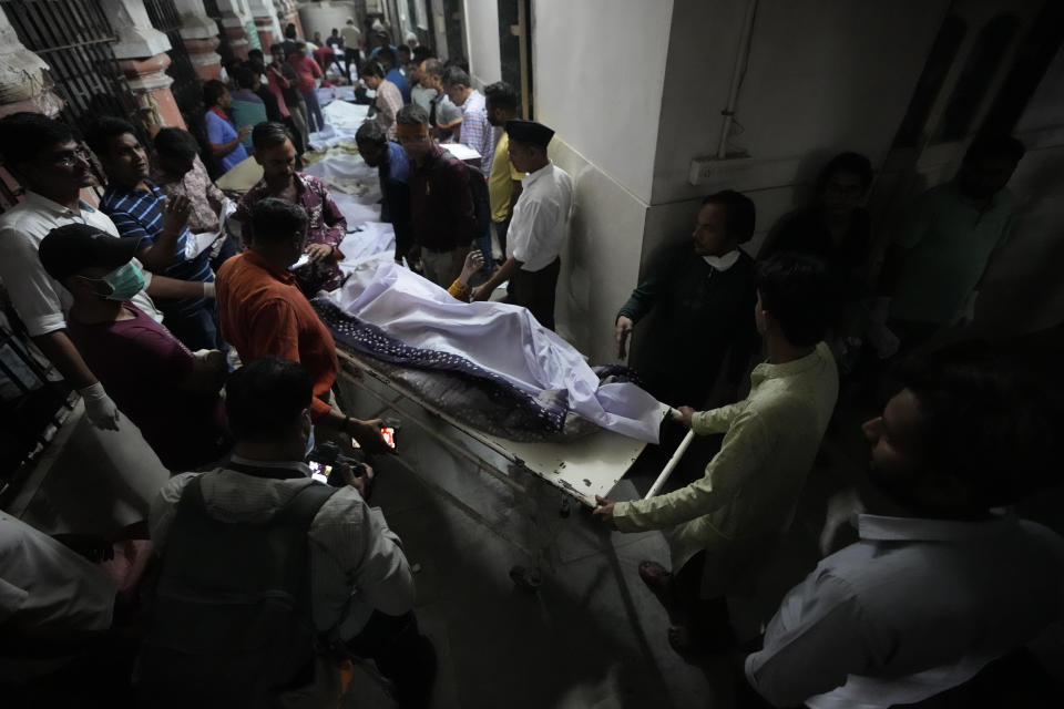 <p>Volunteers and health workers carry a victim after a cable bridge across the Machchu river collapsed in Morbi town of western state Gujarat, India, Monday, Oct. 31, 2022. Dozens are dead and many are feared injured in the accident. (AP Photo/Ajit Solanki)</p> 