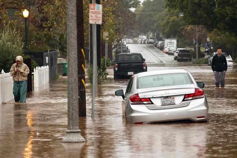 La gente transita con el agua hasta las rodillas a lo largo de una calle inundada como una poderosa tormenta atmosférica de larga duración, la segunda en menos de una semana, impacta California el 4 de febrero de 2024 en Santa Bárbara, California.
(MARIO TAMA / GETTY IMAGES NORTH AMERICA / Getty Images via AFP)