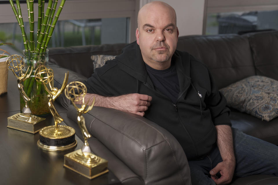 Emmy Award-winning producer Johnathan Walton poses for a photo with his Emmy Awards at his apartment in downtown Los Angeles, Monday, March 25, 2024. Walton was scammed by con artist Marianne "Mair" Smyth, who is now facing extradition to the United Kingdom. Walton started a podcast in 2021, “Queen of the Con,” to warn others about Smyth after he said he was fleeced out of nearly $100,000. (AP Photo/Damian Dovarganes)