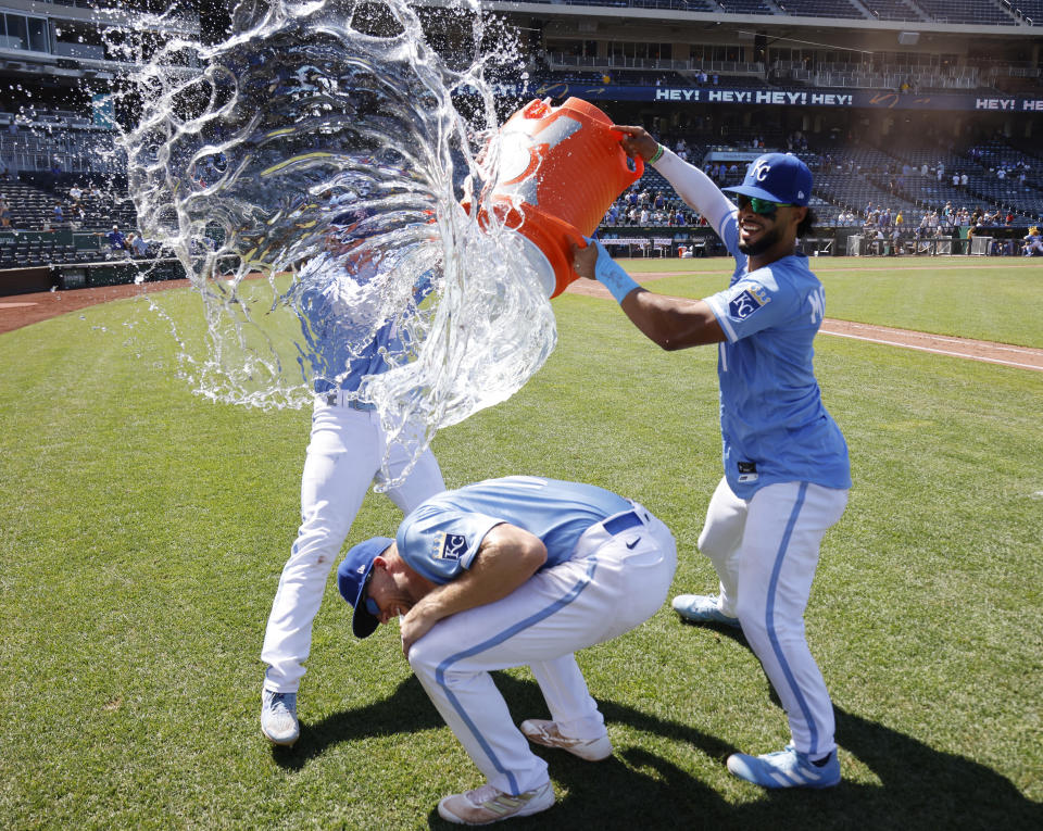 Kansas City Royals' Hunter Dozier, bottom, attempts to avoid getting doused by Bobby Witt Jr., left, and MJ Melendez, right, after a baseball game against the Detroit Tigers in Kansas City, Mo., Wednesday, July 13, 2022. (AP Photo/Colin E. Braley)