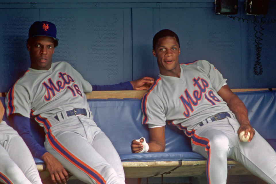 PITTSBURGH, PA - 1986:  Dwight Gooden #16 and Darryl Strawberry #18 of the New York Mets look on from the dugout during a Major League Baseball game against the Pittsburgh Pirates at Three Rivers Stadium in 1986 in Pittsburgh, Pennsylvania.  (Photo by George Gojkovich/Getty Images)