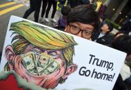 <p>A South Korean protestors displays a placard showing a caricature of President Donald Trump during an anti-Trump rally in Seoul on Nov. 4, 2017, ahead of Trump’s visit to South Korea. (Photo: Jung Yeon-Je/AFP/Getty Images) </p>