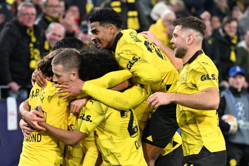 Borussia Dortmund's Marco Reus (L) celebrates his side's second goal of the game during the UEFA Champions League Round of 16, second leg soccer match between Borussia Dortmund and PSV Eindhoven at Signal Iduna Park. Federico Gambarini/dpa