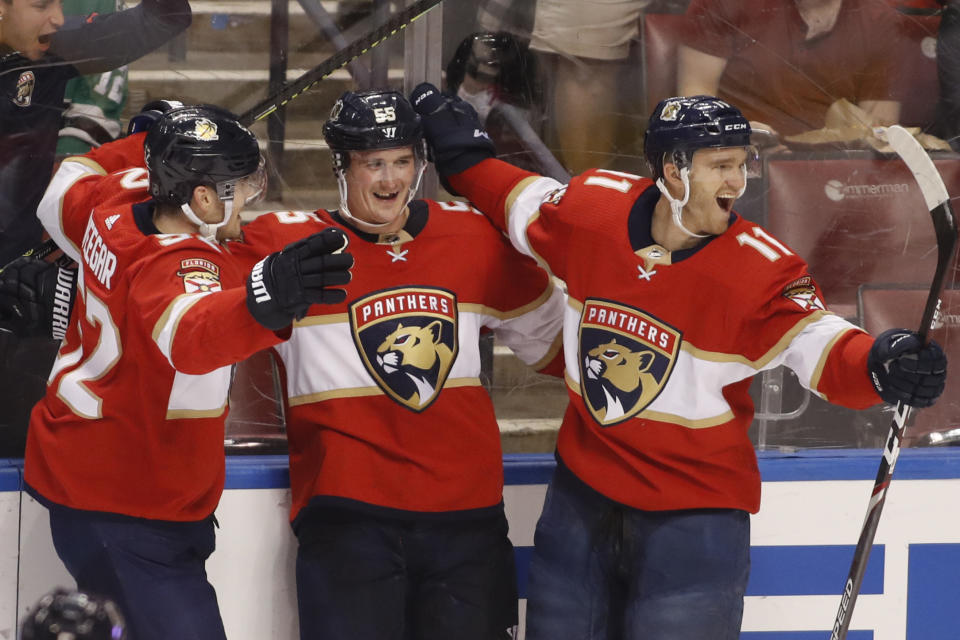 Florida Panthers' Noel Acciari, center, celebrates with teammates MacKenzie Weegar, left, and Jonathan Huberdeau after scoring a goal during the second period of the team's NHL hockey game against the Dallas Stars, Friday, Dec. 20, 2019, in Sunrise, Fla. (AP Photo/Luis M. Alvarez)