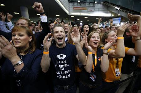 Christian Democratic Union (CDU) party members celebrate after first exit polls in the German general election (Bundestagswahl) at the CDU party headquarters in Berlin September 22, 2013. REUTERS/Fabrizio Bensch