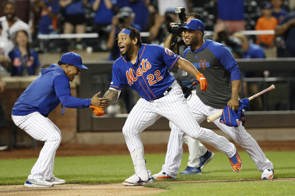 CORRECTS TO THREE-RUN HOME RUN NOT SOLO New York Mets' Marcus Stroman, left, greets Dominic Smith (22) at the plate after Smith hit a walk-off three-run home run in a baseball game against the Atlanta Braves, Sunday, Sept. 29, 2019, in New York. Mets Robinson Cano joins the celebration, right. (AP Photo/Kathy Willens)