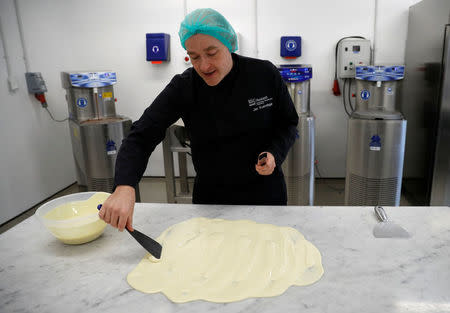 Nestle's Jan Kuendiger spreads white chocolate over a marble work surface in a kitchen at the company's Product Technology Centre in York, Britain, March 21, 2018. Picture taken March 21, 2018. REUTERS/Phil Noble
