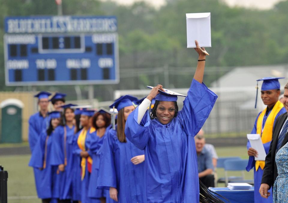 Saria Campbell raises high her diploma during the Blue Hills Regional Technical School graduation in Canton, Tuesday, June, 6, 2023.