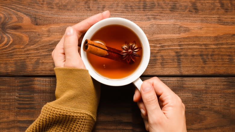 hands holding mug of cinnamon tea