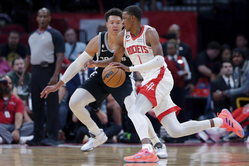 Houston Rockets forward Jabari Smith Jr. (1) drives around San Antonio Spurs forward Isaiah Roby, left, during the first half of an NBA basketball game Sunday, Oct. 2, 2022, in Houston. (AP Photo/Michael Wyke)