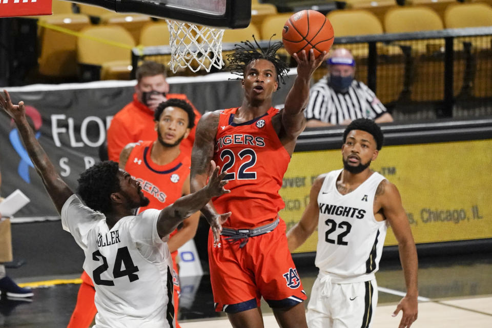 Auburn guard Allen Flanigan, center, shoots as he gets between Central Florida guards Dre Fuller Jr. (24) and Darin Green Jr., right, during the second half of an NCAA college basketball game, Monday, Nov. 30, 2020, in Orlando, Fla. (AP Photo/John Raoux)