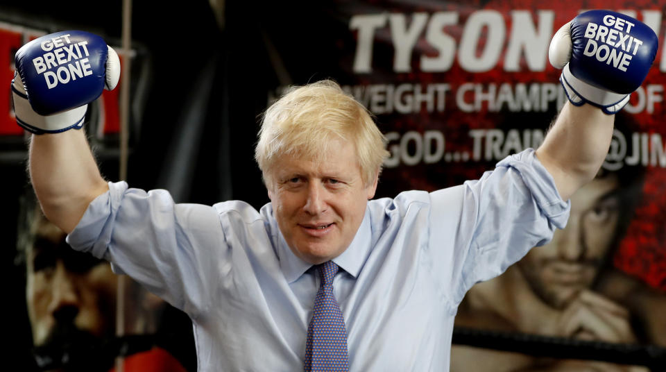 Britain's Prime Minister Boris Johnson poses for a photo wearing boxing gloves during a stop in his General Election Campaign trail at Jimmy Egan's Boxing Academy in Manchester, England, Tuesday, Nov. 19, 2019. Britain goes to the polls on Dec.12. (AP Photo/Frank Augstein)