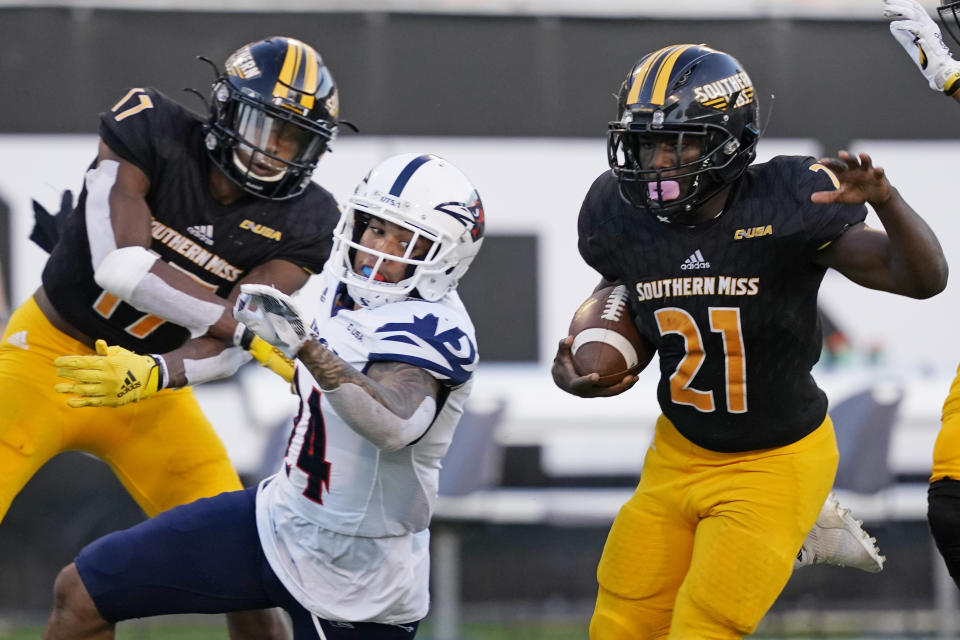 Southern Mississippi running back Frank Gore Jr. (21) is assisted by wide receiver Jason Brownlee's (17) block on UTSA safety SaVion Harris, as he scores on a 51-yard touchdown pass reception during the second half of an NCAA college football game, Saturday, Nov. 21, 2020, in Hattiesburg, Miss. UTSA won 23-20. (AP Photo/Rogelio V. Solis)