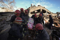 Rescue teams evacuate a survivor from the rubble of a destroyed building in Kahramanmaras, southern Turkey, Tuesday, Feb. 7, 2023. A powerful earthquake hit southeast Turkey and Syria early Monday, toppling hundreds of buildings and killing and injuring thousands of people. (AP Photo/Khalil Hamra)