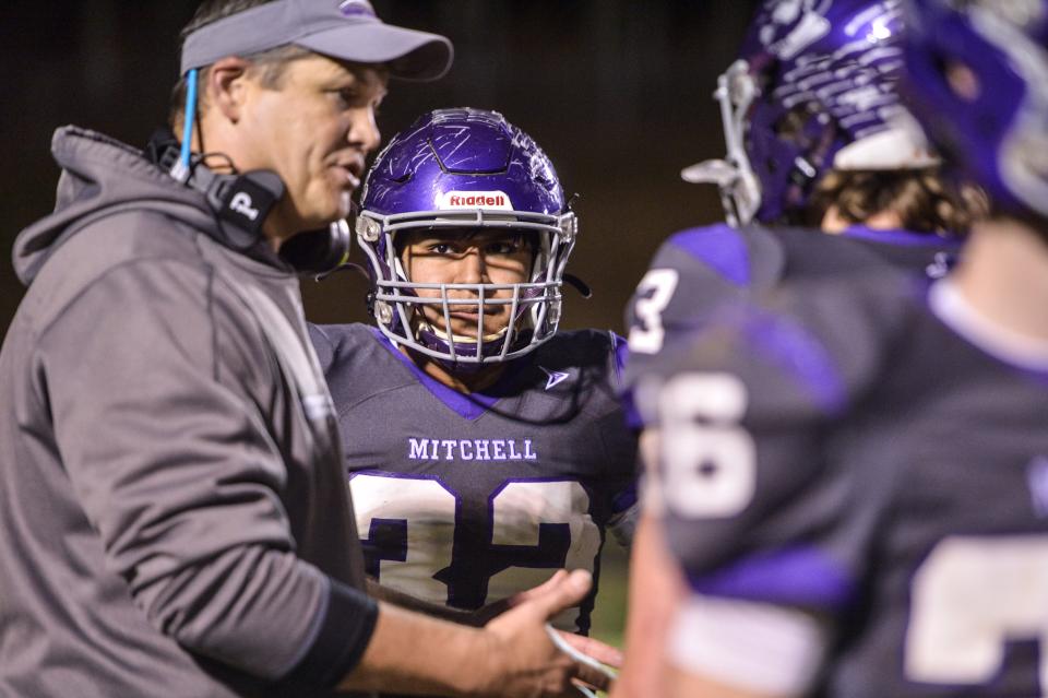 Mitchell's Enrique Huaroco (32) listens to head coach Travise Pitman during their game against Robbinsville on December 3, 2021. Mitchell defeated Robbinsville 34-21 to become the 2021 regional champions.