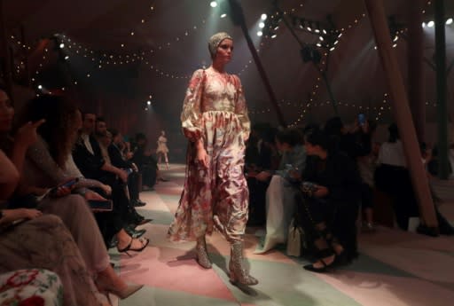 A model walks the runway under the watchful eye of fashion lovers and influencers for Dior's "parade" in Dubai -- the house's first show in the emirate, featuring a 15-piece capsule collection