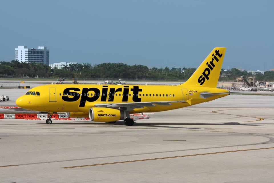 A Spirit Airlines jet is shown on a taxiway. The airline is an ultra-low-fare carrier.