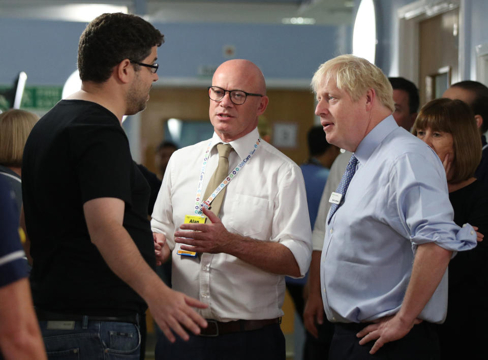 Britain's Prime Minister Boris Johnson (R) listens as the father of a young girl, who is being treated in the Acorn childrens' ward, expresses his anger over hospital waiting times during his visit to Whipps Cross University Hospital in Leytonstone, east London on September 18, 2019. (Photo by Yui Mok / POOL / AFP)        (Photo credit should read YUI MOK/AFP/Getty Images)