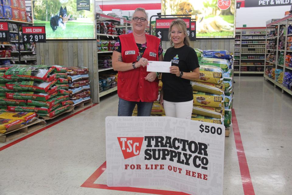 Heidi Riehl presents a gift card to Janelle Repp with Raccoon River Pet Rescue during a ribbon cutting ceremony on Friday, Aug. 11, 2023, at Tractor Supply Co. in Perry.