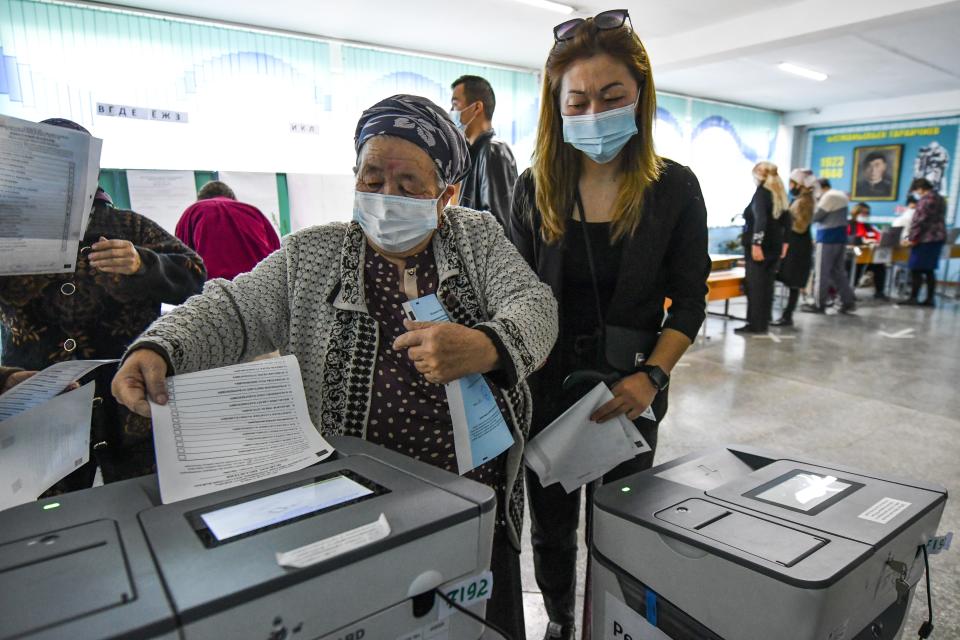 A woman casts her ballot at a polling station during the referendum in Bishkek, Kyrgyzstan, Sunday, April 11, 2021. Voters in Kyrgyzstan cast ballots Sunday on whether to approve a new constitution that would substantially increase the president's powers. The Sunday referendum comes three months after Sadyr Zhaparov was elected president, following the ouster of the previous president amid protests, the third time in 15 years that a leader of the Central Asian country had been driven from office in a popular uprising. (AP Photo/Vladimir Voronin)