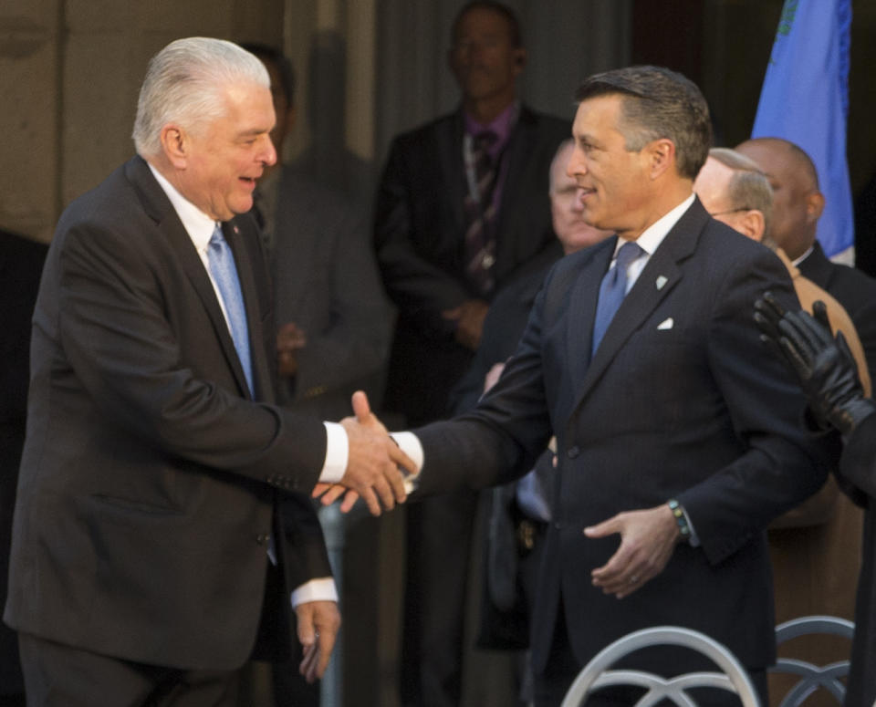 Governor-elect Steve Sisolak is congratulated by Governor Brian Sandoval during his inauguration on the steps of the Nevada State Capitol in Carson City, Nev., Monday, Jan. 7, 2019. (AP Photo/Tom R. Smedes)